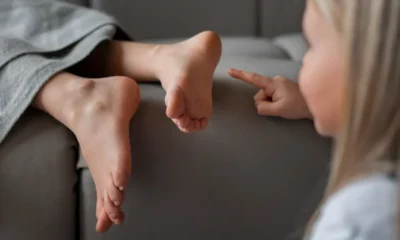 bambina indica piedi di donna distesa