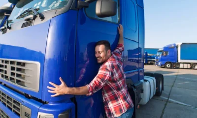 camionista abbraccia il suo camion iveco blu