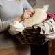 casalinga sostiene cesta del bucato con detersivo