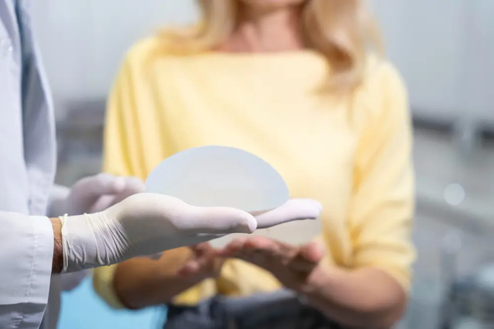 chirugo plastico mostra protesi seno a paziente donna