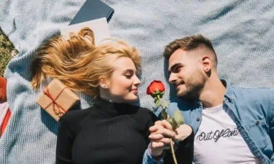 coppia di innamorati stesi si guardano negli occhi sorridenti
