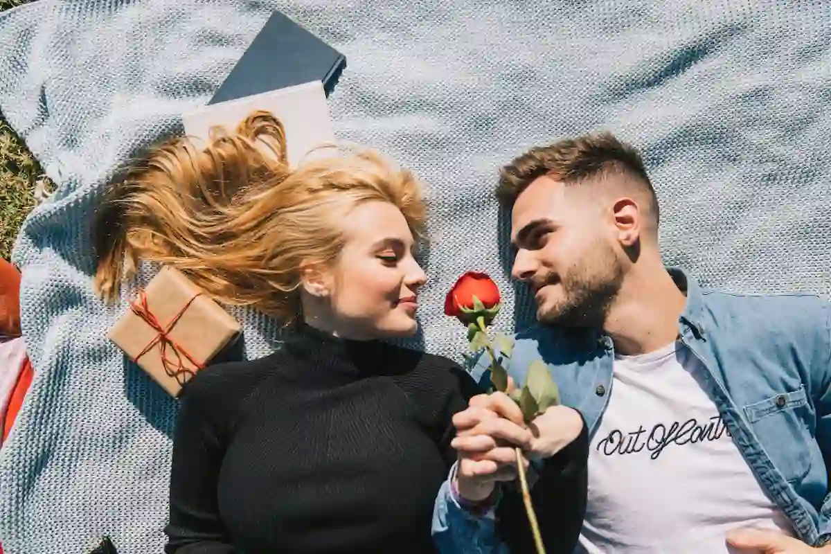 coppia di innamorati stesi si guardano negli occhi sorridenti