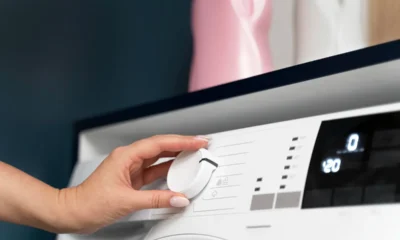 donna con la mano regola funzionamento della lavatrice