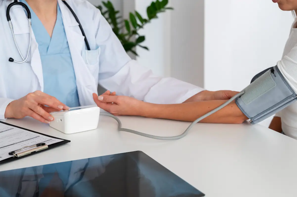 dottoressa intenta a misurare la pressione a un uomo