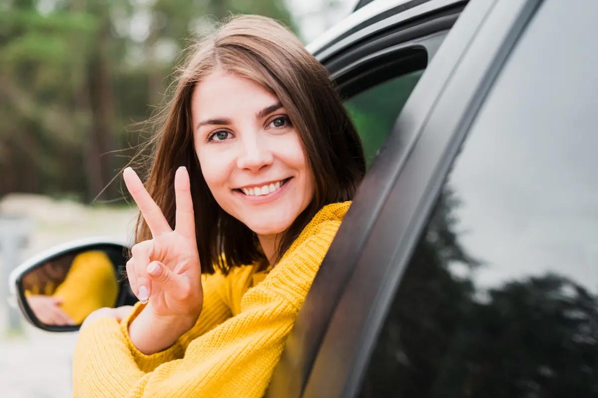 giovane ragazza neopatentata fa segno vittoria