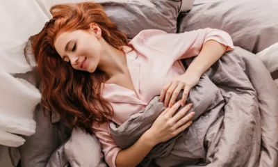 ragazza che dorme su dei cuscini di colore rosa