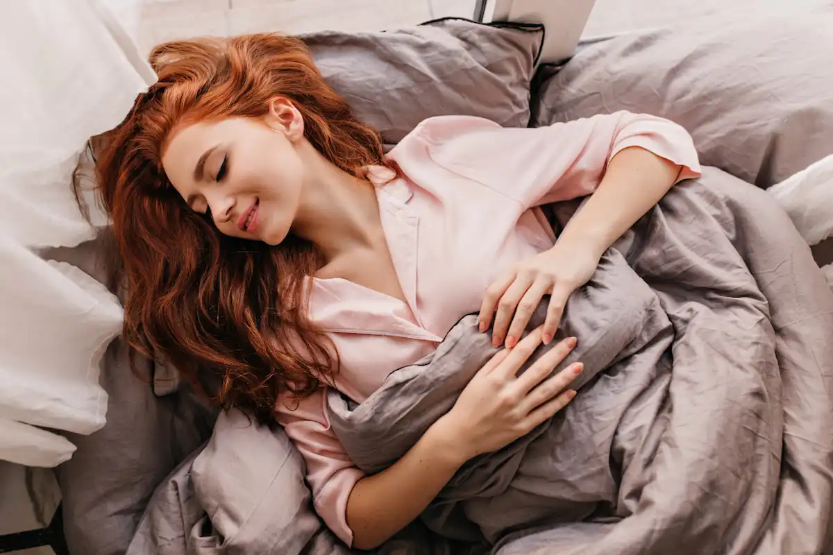 ragazza che dorme su dei cuscini di colore rosa