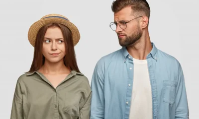 ragazza con cappello accanto a fidanzato con occhiali