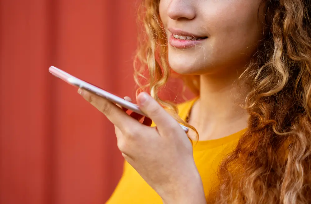 ragazza riccia capelli rossi parla telefono in mano
