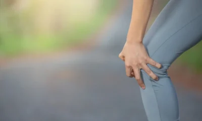 ragazza tocca ginocchio dolorante che lo piega