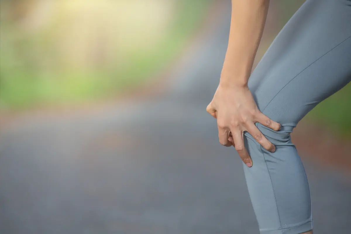 ragazza tocca ginocchio dolorante che lo piega