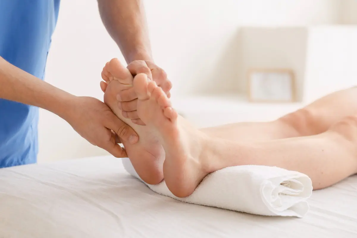 un podologo mentre massaggia piede destro di paziente