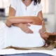 una osteopata mentre scrocchia la schiena a una paziente