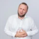 uomo di mezza etá con barba soffre di reflusso gastroesofageo