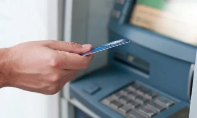 uomo preleva soldi da un atm con la carta di debito