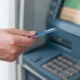 uomo preleva soldi da un atm con la carta di debito