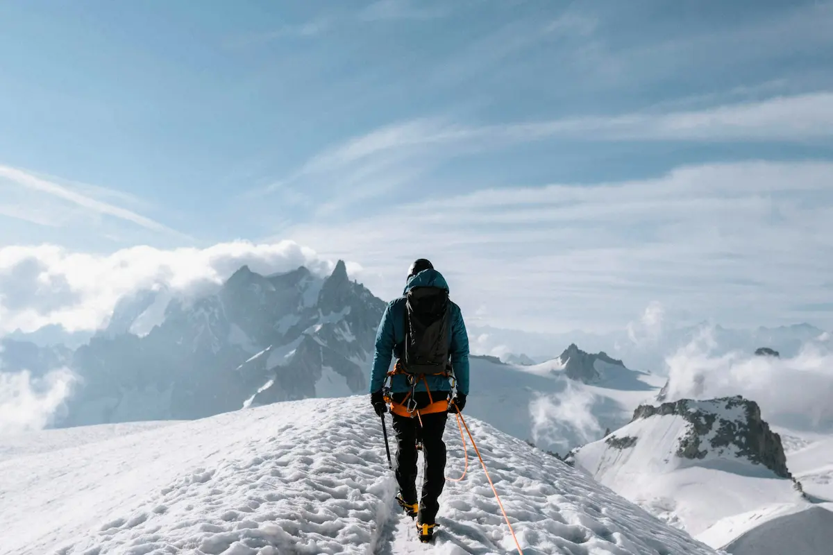 alpinista sulla vetta di un monte innevato