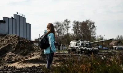 bambina ucraina cammina tra macerie e tank