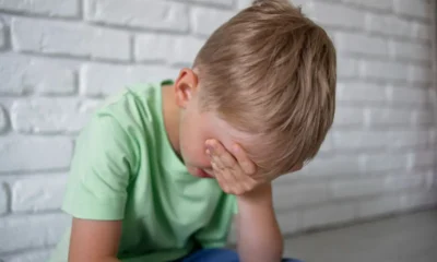 bambino con mal di testa con mano su occhi