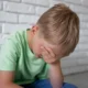 bambino con mal di testa con mano su occhi