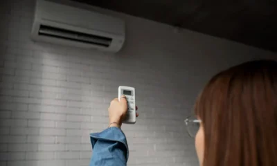 donna accende condizionatore con telecomando