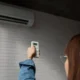 donna accende condizionatore con telecomando