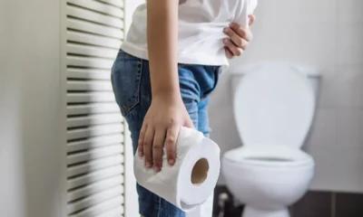 donna con carta igienica accanto a water
