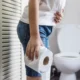 donna con carta igienica accanto a water