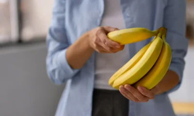 donna mentre prende una banana da un ceppo