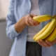 donna mentre prende una banana da un ceppo