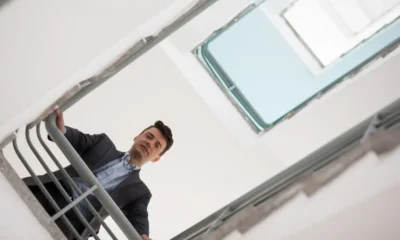 lavoratore guarda in basso da una scala