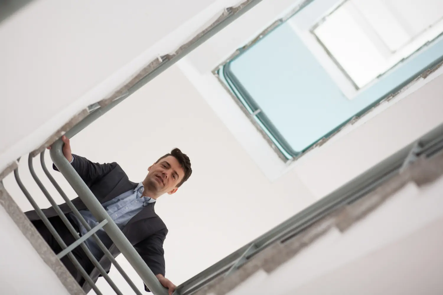 lavoratore guarda in basso da una scala