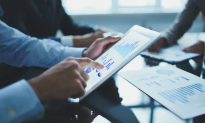 mani di broker su ipad con dati finanzari