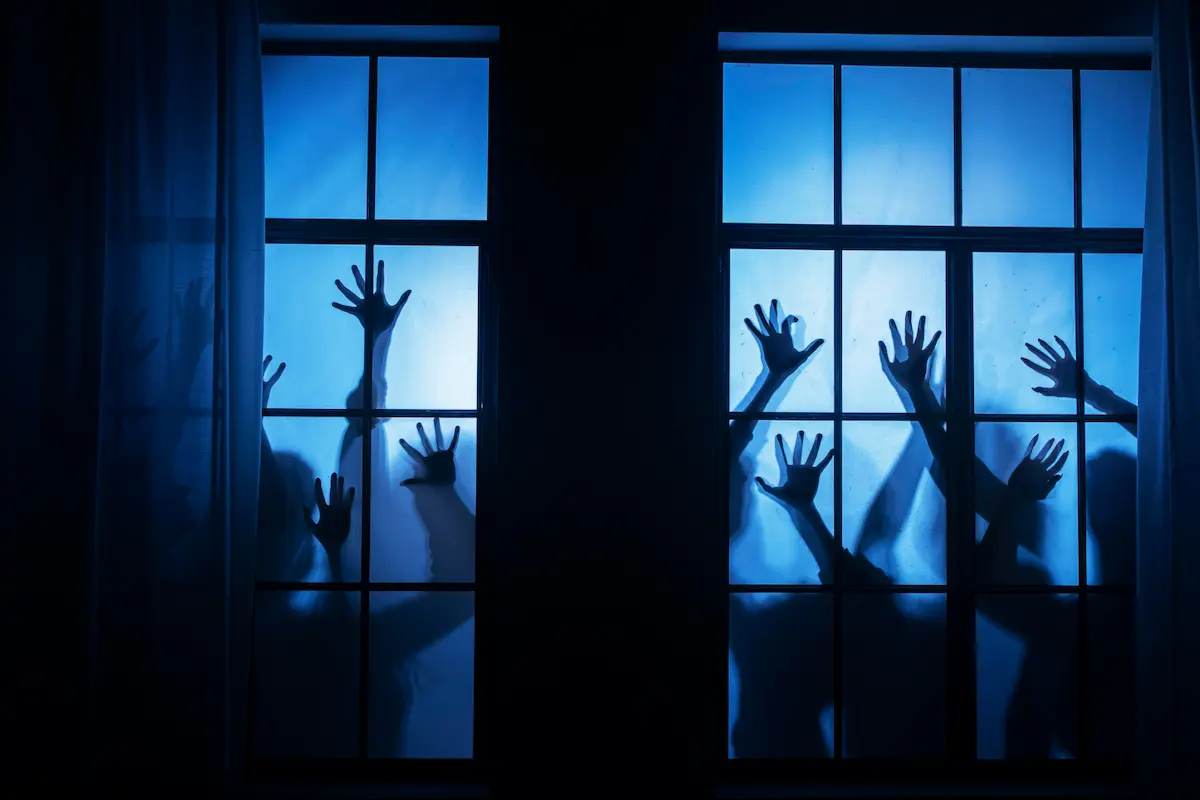 mani di fantasmi su una finestra blu horror