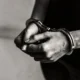 mani di uomo con manette in bianco e nero
