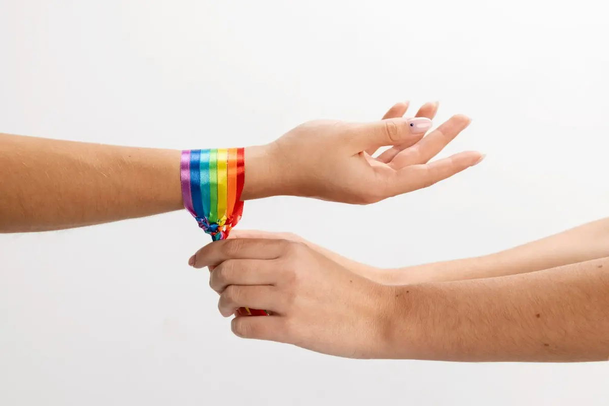 mano allaccia braccialetto lgbt a altra mano