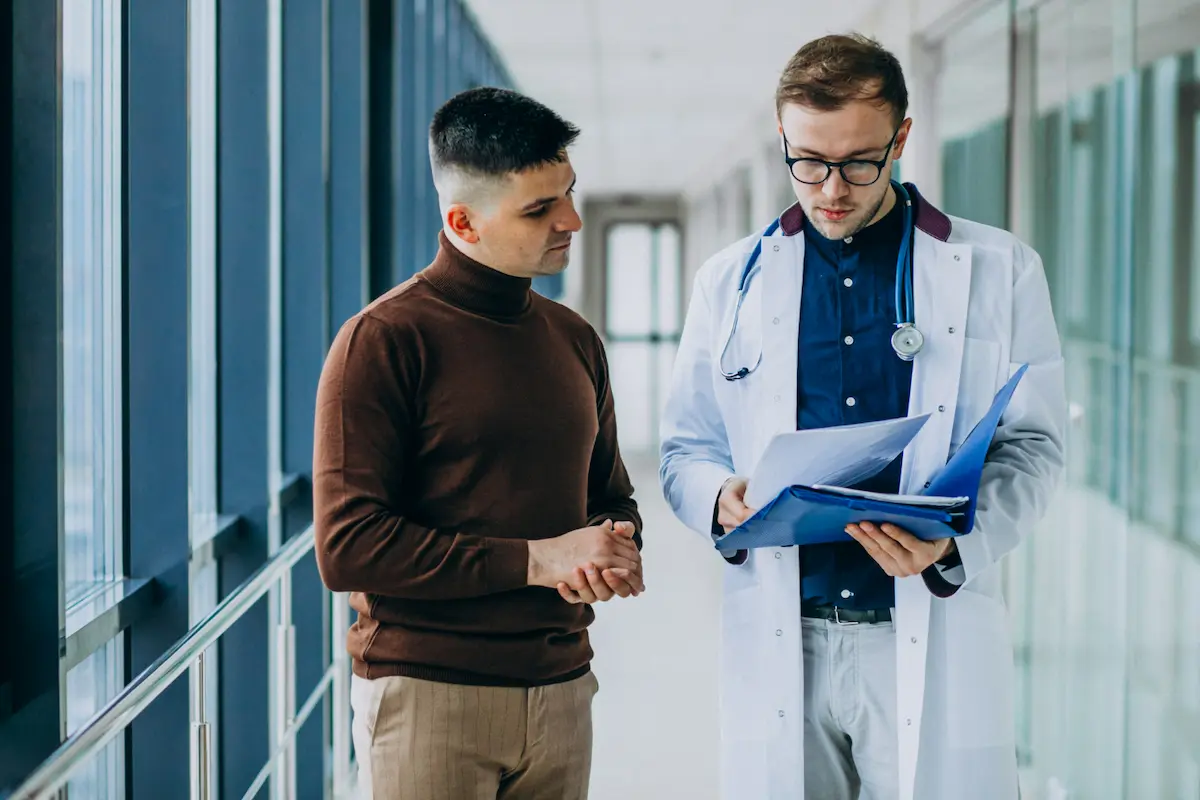 medico parla con paziente in corridoio
