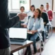 professore da una lezione a vari ragazzi con pc