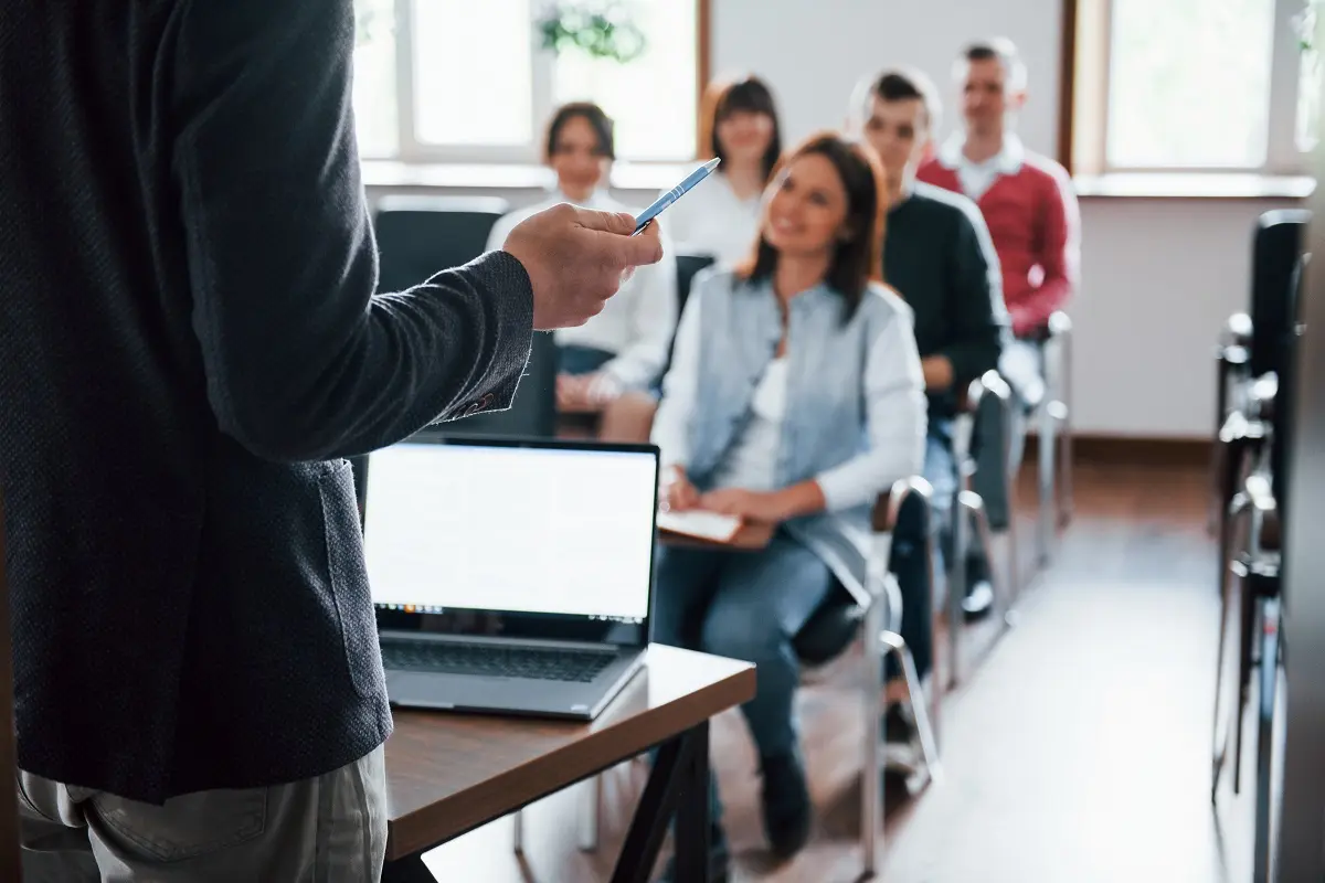 professore da una lezione a vari ragazzi con pc