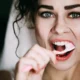 ragazza che si lava i denti allo specchio