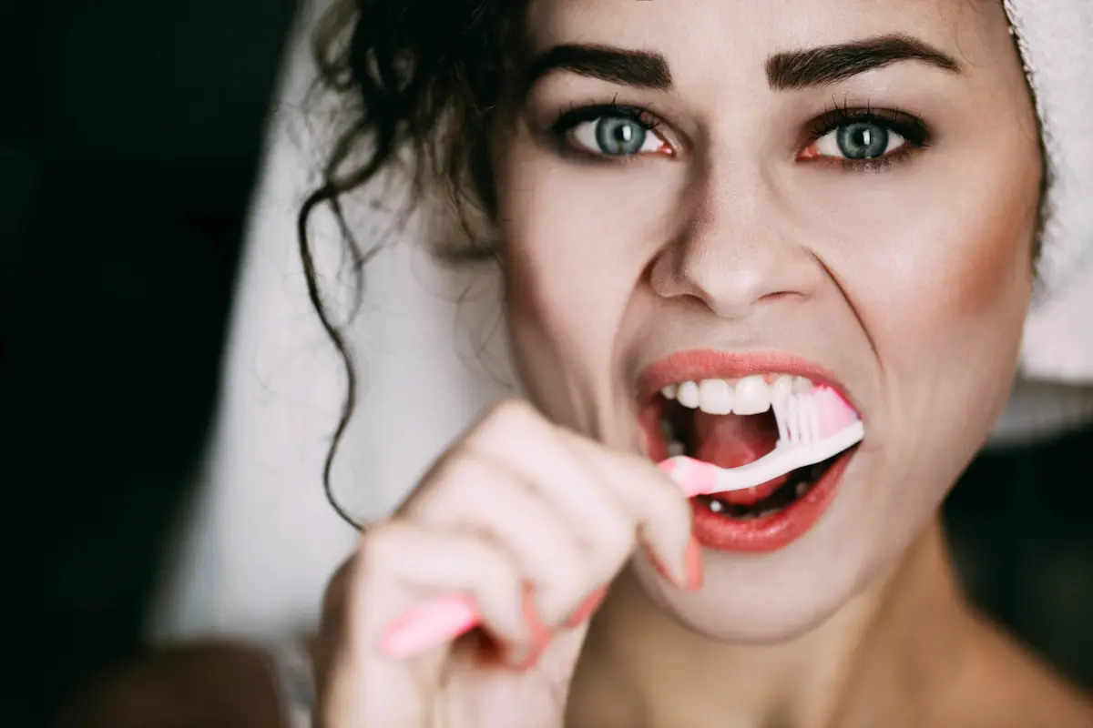 ragazza che si lava i denti allo specchio