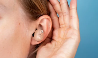 ragazza mostra orecchia con apparecchio acustico