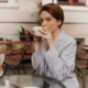 ragazza seduta in vestaglia beve ceffe