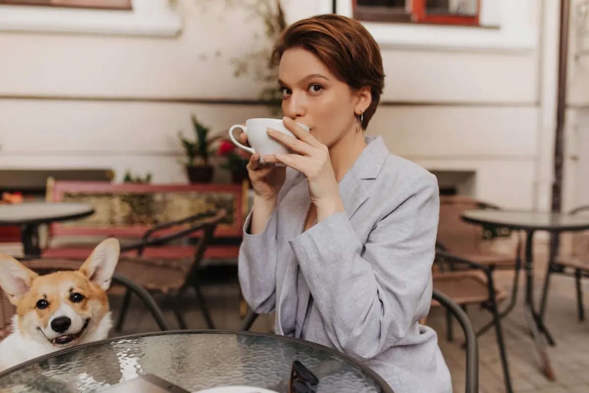 ragazza seduta in vestaglia beve ceffe