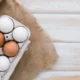 un cartone di uova bianche e normali