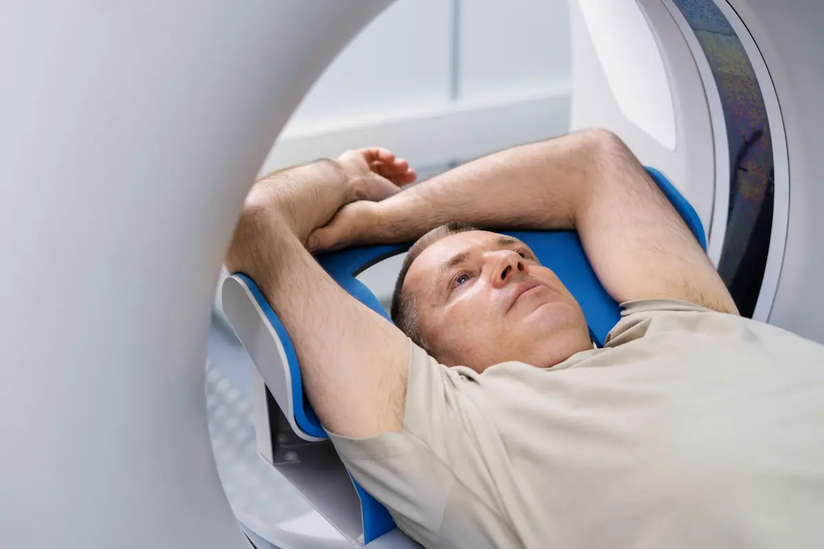 uomo sdraiato mentre fa una tomografia pet