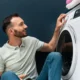 uomo sorride davanti a lavatrice
