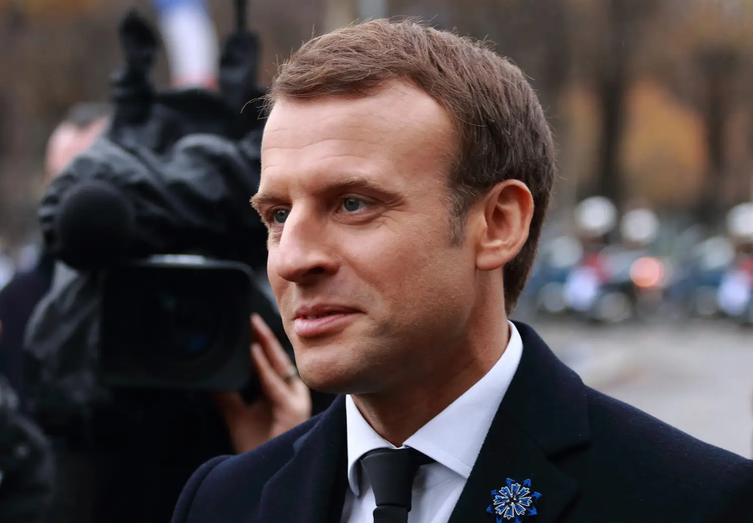 Emannuel Macron sorride in una strada