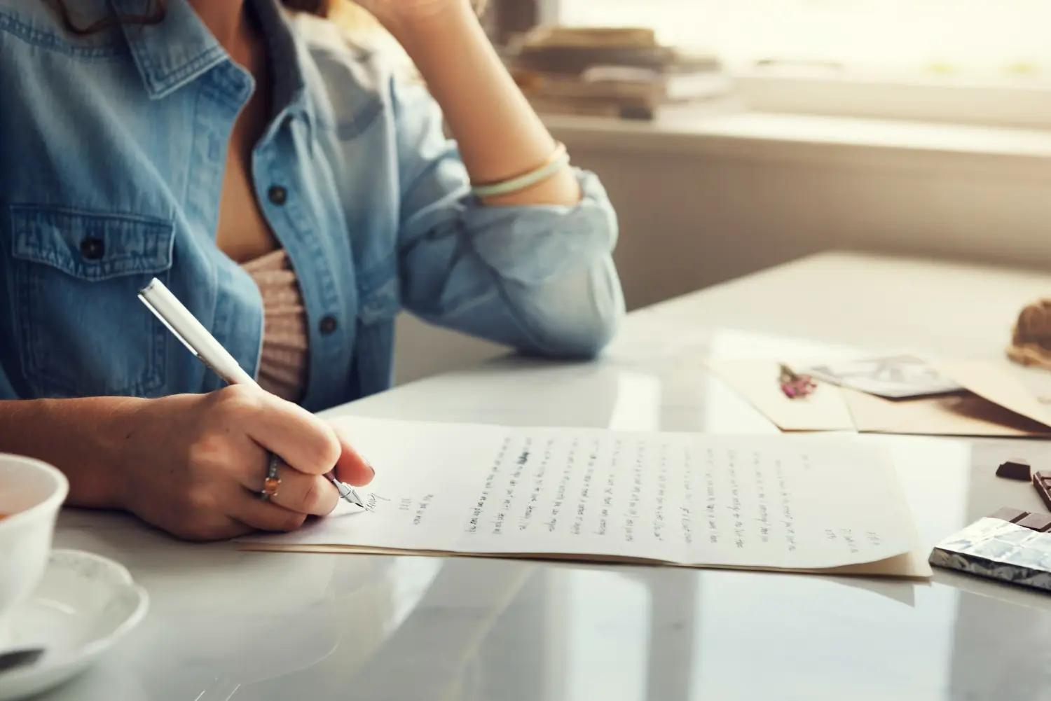 donna scrive una lettera a mano