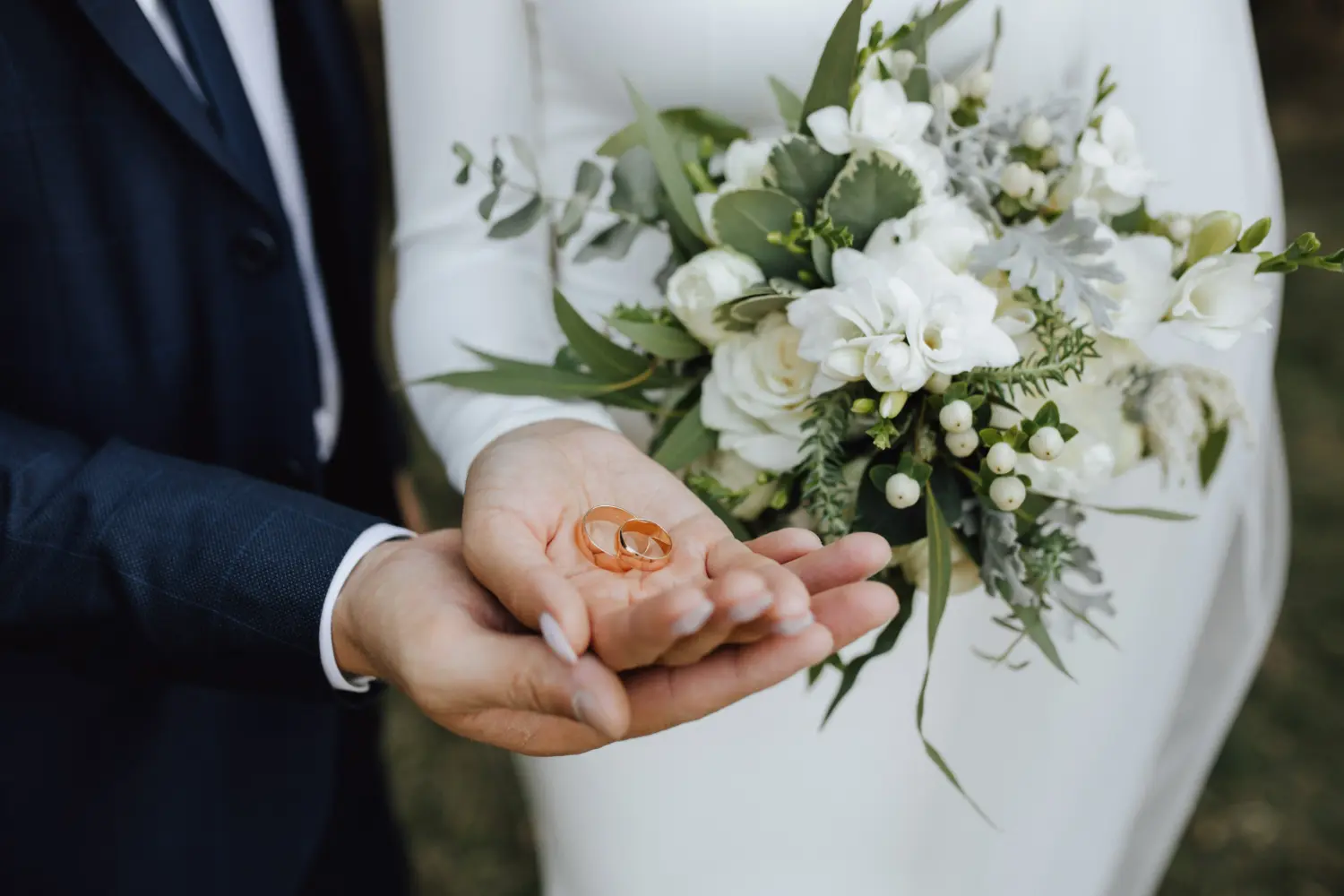 due sposi mostrano boquet e fedi